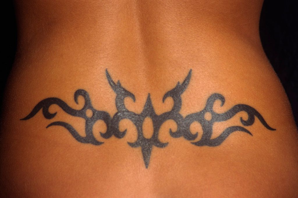 een damesonderrug met daarop een merkwaardig gew tattoeage van een gewei getatoeëerd