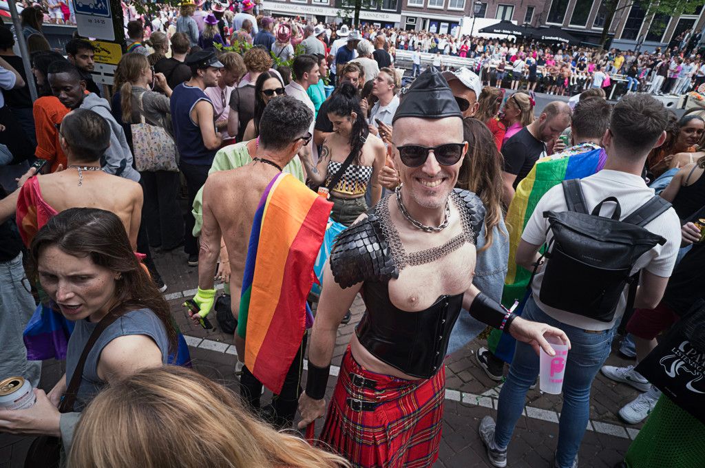 een man gekleed in veel leer met een zonnebril op heeft het ogenschijnlijk naar zijn zin tijdens pride