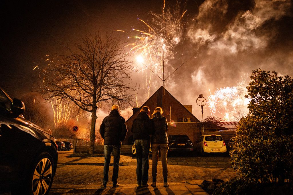 Gezin kijkt naar vuurwerk tijdens nieuwjaarsnacht