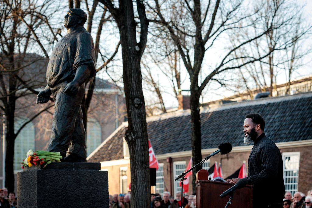 jerry afriyie in beeld gevangen met de dokwerker tijdens de herdenking van de februaristaking
